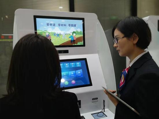 工作人員指導(dǎo)市民使用自助服務(wù)機(jī)。浙江省人社廳供圖